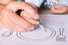 child drawing food onto plate.png