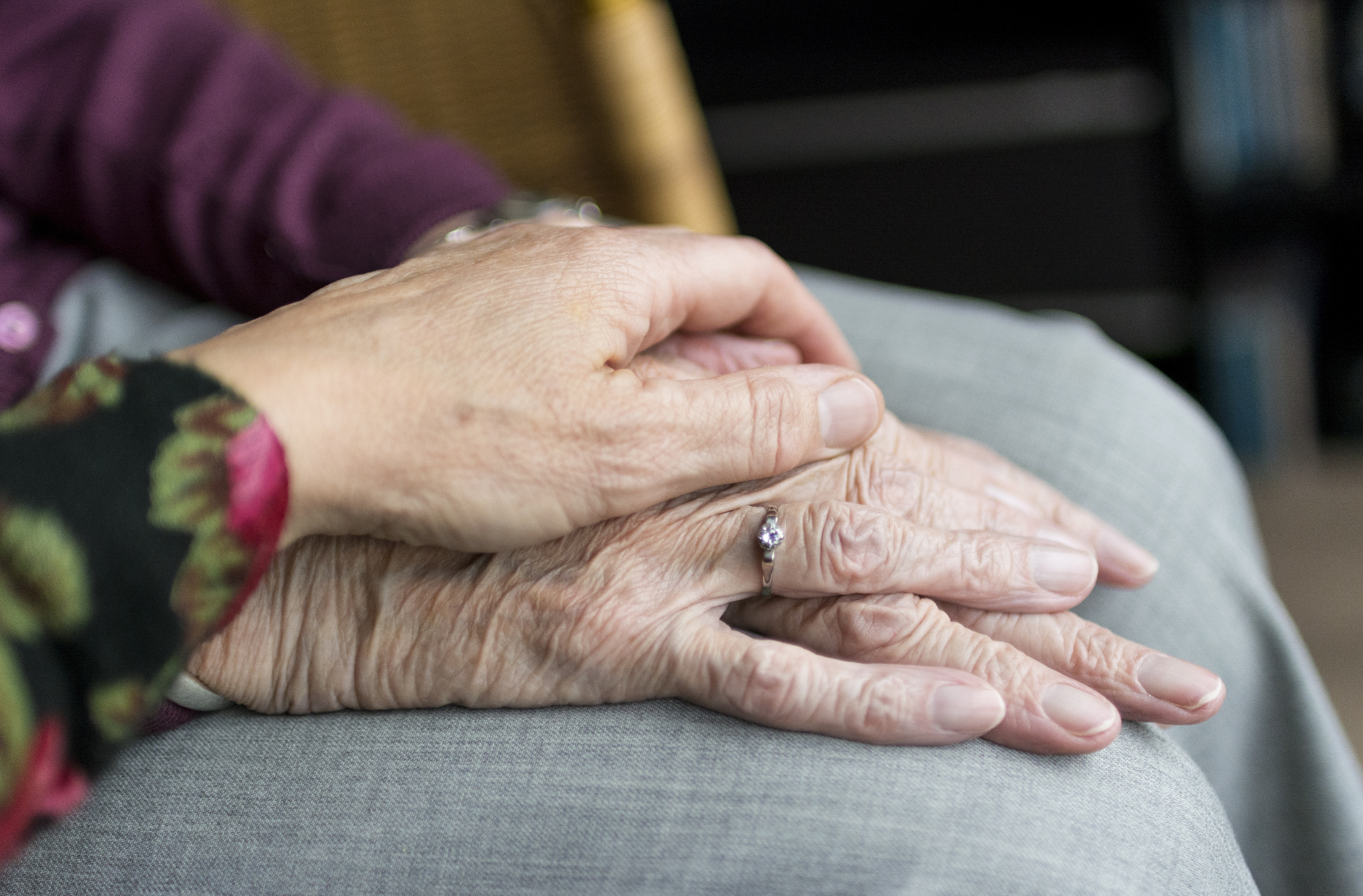 Patient holding hands in home.png